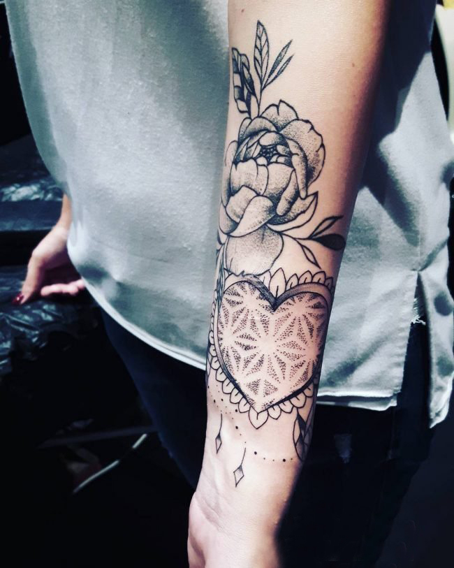 女生手臂上黑灰素描创意心形和花朵纹身图片
